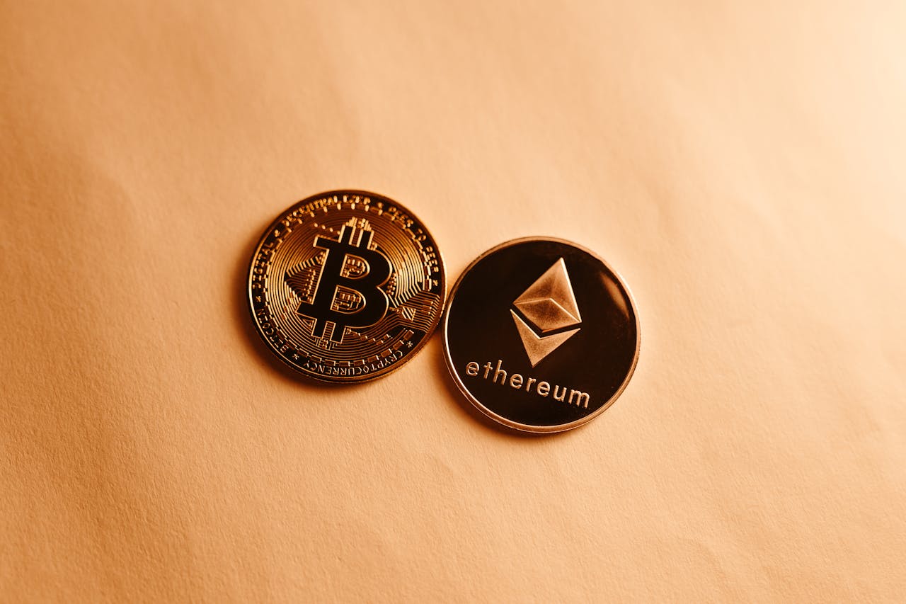Bitcoin and Ethereum coins depicted on a soft yellow background for cryptocurrency and finance themes.